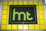 glass, mosaic, art, floor, emblem, logo, hmt, hold my ticket, entry way, green, black, yellow